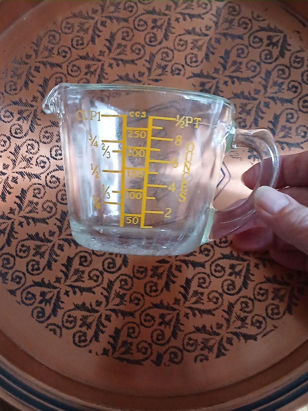 Vintage Pyrex measuring cup with yellow lettering